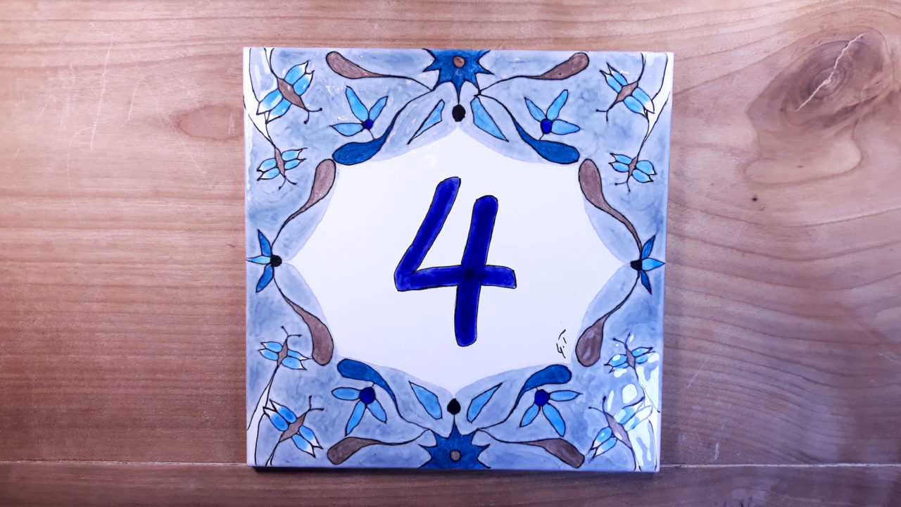 Numéro de maison céramique sur une table en bois couleur bleu numéro d'exemple 4 motifs papillons et fleurs