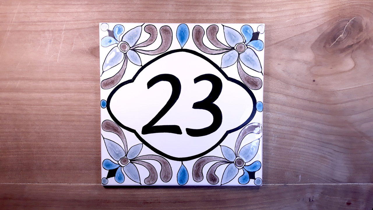 Numéro de maison céramique numéro d'exemple 23 fond blanc sur table en bois design personnalisable original, motifs gris et bleus florales