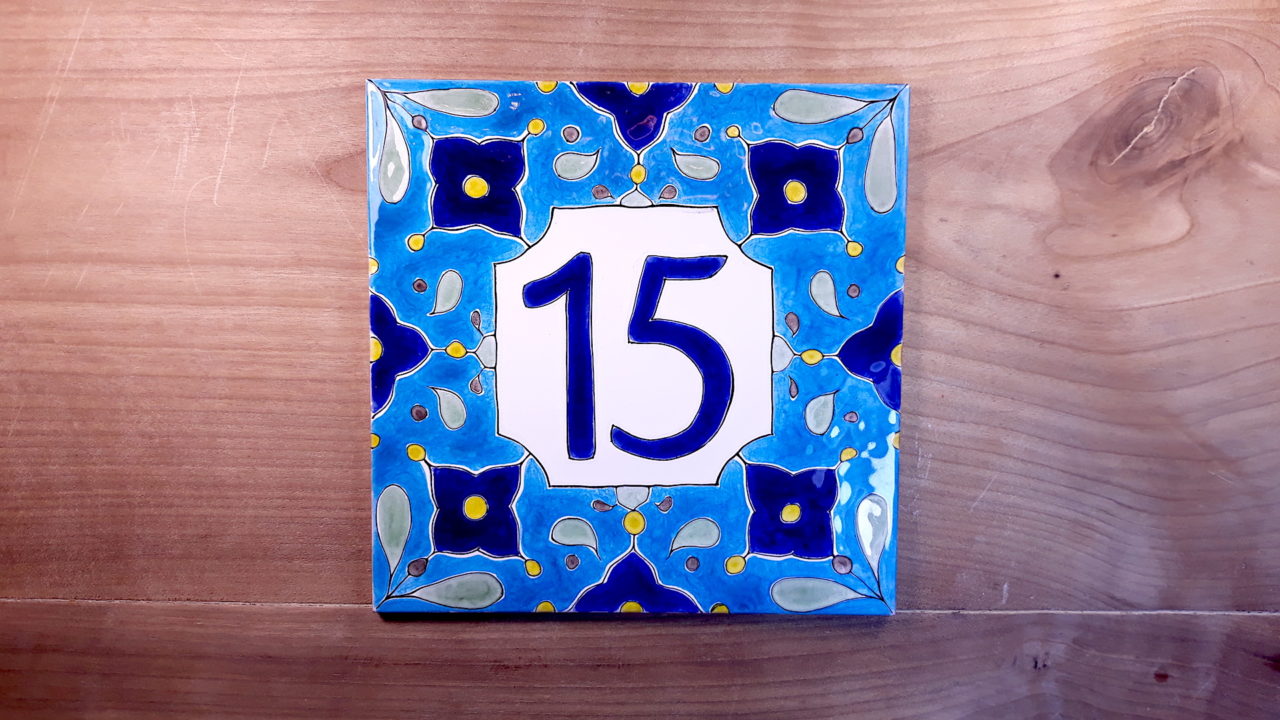 Numéro de maison céramique sur table en bois numéro d'exemple 15 fond bleus motifs bleus et jaunes symétriques design original personnalisable et moderne